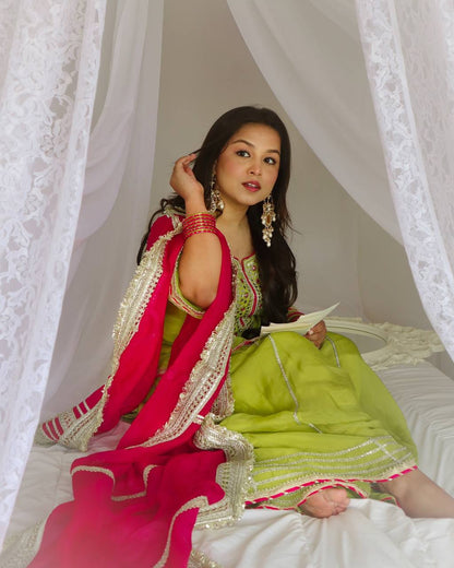 Vibrant lime green traditional outfit with pink and gold accents.